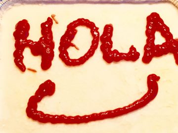 Lasaña boloñesa en la que hemos escrito la palabra hola con ketchup antes de meterla en el horno