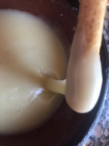 Cremosa fondue de queso. Se aprecia el momento en el que mojamos un piquito de pan en la recién sacada del microondas fondue.