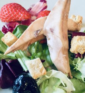 Ensalada de perdiz escabechada con fresas. Detalle de las ciruelas pasas sin hueso y los picatostes.