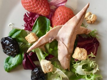 Ensalada de perdiz escabechada con fresas. Ciruelas pasas, picatostes y vinagreta de miel de caña.