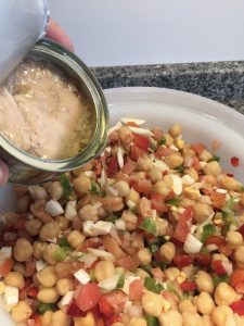 Añadiendo el atún claro en aceite de oliva a la ensalada de garbanzos.