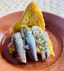 Tapa de tortilla de patatas rellena de boquerones y lacón.