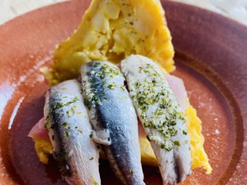 Tapa de tortilla de patatas rellena de boquerones y lacón.